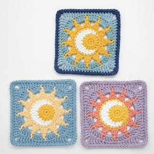 Pode incluir: Tr&ecirc;s quadrados de croch&ecirc; com um desenho de sol e lua. Cada quadrado apresenta um esquema de cores diferente: azul, amarelo e branco; azul, amarelo e creme; e roxo, laranja e creme. Os quadrados s&atilde;o quadrados com uma borda.