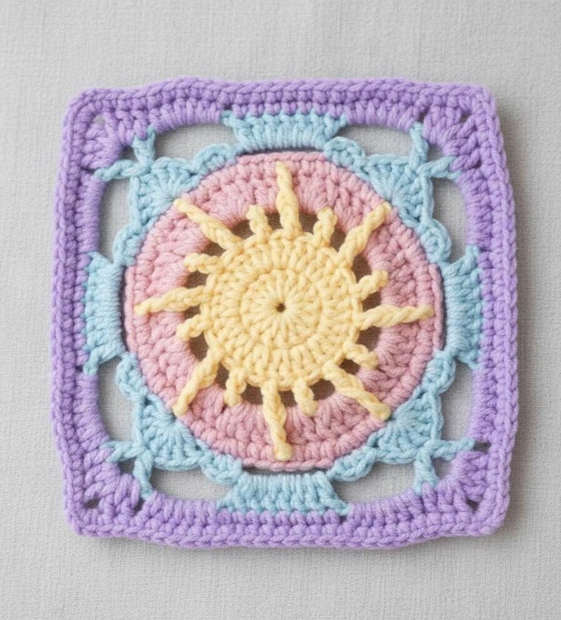 May include: A square, crocheted sunburst design in pastel colors. The center features a yellow sun shape surrounded by a pink circle. Light blue and lavender crochet work frames the design, creating a textured, handmade appearance. This item is suitable for various craft projects.