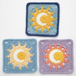 May include: Three crocheted square coasters with a sun and moon design. The coasters feature a yellow sun with a white crescent moon in the center, set against a blue, light blue, and purple background. The edges are a darker blue and purple.