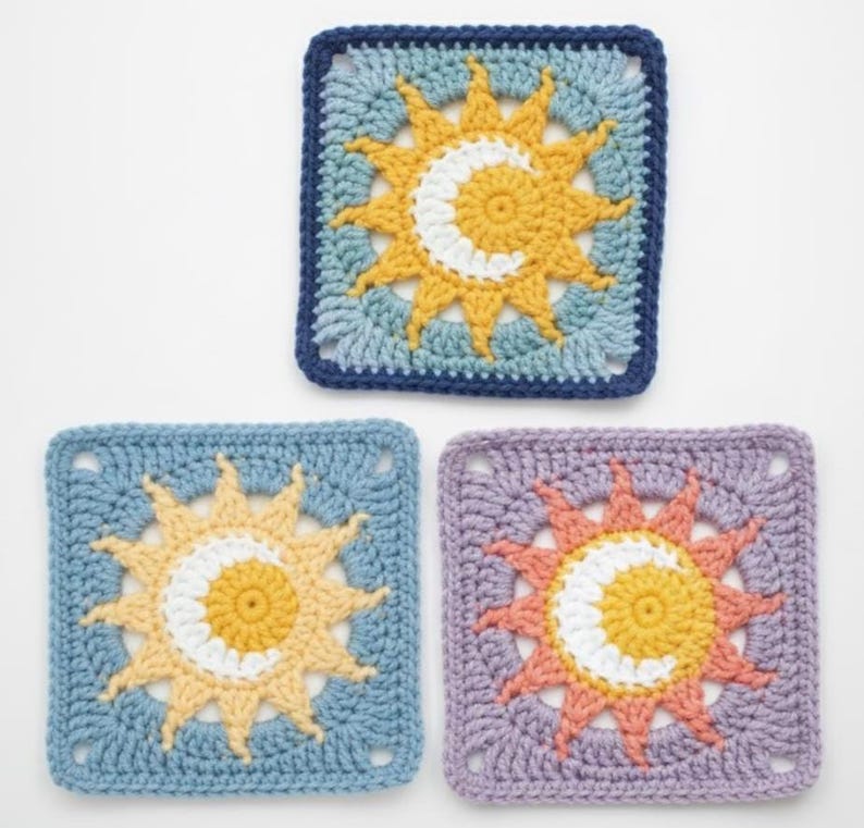 May include: Three crocheted square coasters with a sun and moon design. The coasters feature a yellow sun with a white crescent moon in the center, set against a blue, light blue, and purple background. The edges are a darker blue and purple.
