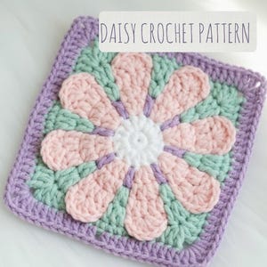 May include: A square crochet piece featuring a daisy design. The flower has a white center, pink petals, and is surrounded by green and purple crochet. The text "DAISY CROCHET PATTERN" is displayed on a white rectangle.