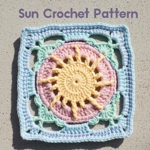 May include: A square crochet pattern featuring a sun design. The sun is yellow with pink and blue accents. The text "Sun Crochet Pattern" is at the top. The crochet work is in pastel colors.