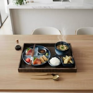 Puede incluir: Un conjunto de comida japonesa en una bandeja de madera. El conjunto incluye sashimi, sopa de miso, arroz, tempura y salsas. También hay palillos y utensilios dorados. La comida está dispuesta sobre una mesa de madera.