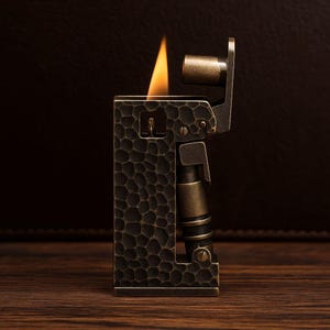 Op de afbeelding: Een vintage-stijl aansteker met een getextureerde, donkerbronzen afwerking. De aansteker heeft een rechthoekige behuizing met een gedetailleerd patroon en een vlam die van bovenaf komt. Het ontwerp bevat metalen accenten en een mechanische uitstraling.