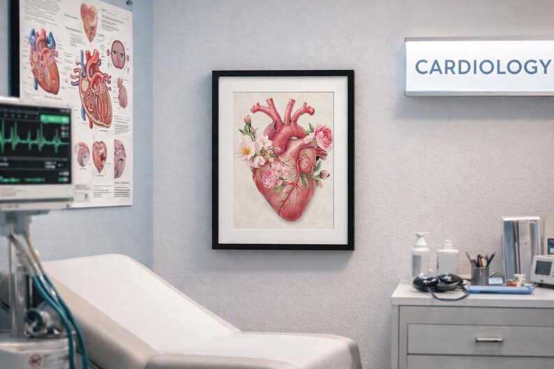 Puede incluir: Impresi&oacute;n enmarcada de acuarela de un coraz&oacute;n humano adornado con flores rosas y blancas. La obra de arte se exhibe en un entorno m&eacute;dico, con un letrero de cardiolog&iacute;a en el fondo. La impresi&oacute;n est&aacute; en un marco negro.