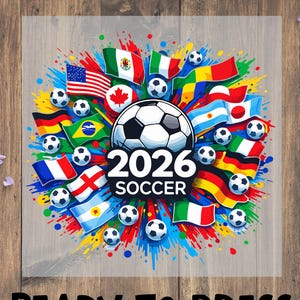 May include: A graphic design for a soccer event, featuring a soccer ball with "2026 SOCCER" text. The design includes flags from various countries and soccer balls, with the text "READY TO PRESS" at the bottom.