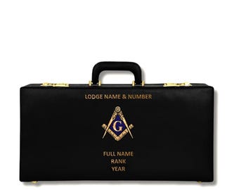 Puede incluir: Maletín negro con herrajes dorados y asa negra. La parte delantera presenta un emblema masónico y el texto "LODGE NAME & NUMBER", "FULL NAME", "RANK" y "YEAR".