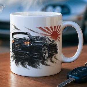 Könnte beinhalten: Weiße Keramiktasse mit einer Grafik eines schwarzen Sportwagens und einem Sonnenaufgangsdesign. Dampf steigt aus der Tasse auf, was auf ein heißes Getränk hindeutet. Autoschlüssel liegen auf einer Holzoberfläche, im Hintergrund ein silbernes Auto.