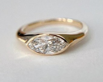 Förlovningsring i 14 karat guld med marquise och moissanit i öst-västlig bezel