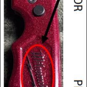 May include: A red utility knife with a black blade. The handle has a glittery finish and a small, etched design. The knife is designed for cutting and general use.