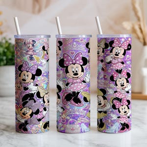Op de afbeelding: Drie cilindrische bekers met doorzichtige deksels en witte rietjes, voorzien van een herhalend patroon van Minnie Mouse in diverse houdingen, gekleed in roze jurken met stippen en strikken, tegen een levendige paarse achtergrond met glitters.