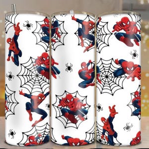 May include: A white tumbler featuring a repeating pattern of Spider-Man in various action poses, set against black spiderwebs and small black spiders. The superhero is depicted in his classic red and blue suit. The tumbler includes a silver straw.