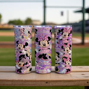 Op de afbeelding: Drie cilindrische bekers met een herhalend patroon van Minnie Mouse in verschillende houdingen, gekleed in roze jurken met stippen en strikken. De achtergrond van de bekers is levendig paars met holografische glitters, hartjes en kronen.