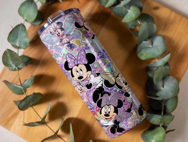 Op de afbeelding: Een cilindrische roestvrijstalen beker met een levendige, holografische wikkel met meerdere illustraties van Minnie Mouse in verschillende houdingen, gekleed in paarse en roze outfits, geaccentueerd door glinsterende glitter en fee-achtige vleugels.