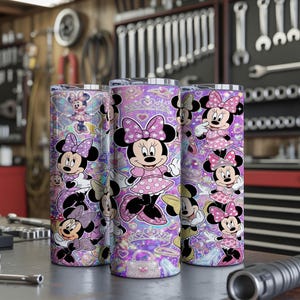 Op de afbeelding: Drie cilindrische bekers met een herhalend patroon van Minnie Mouse in verschillende houdingen, gekleed in roze jurken met stippen en strikken. De achtergrond is een levendig paars met glinsterende ster-, hart- en tiaramotieven.