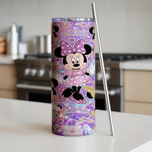 Op de afbeelding: Een cilindervormige roestvrijstalen beker met een herhalend patroon van Minnie Mouse in een roze jurk met stippen en strik, afgewisseld met glinsterende tiara's, handtassen en hartjes op een levendige paarse achtergrond, inclusief een metalen rietje.