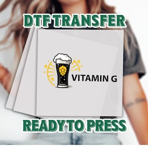May include: A DTF transfer featuring a black beer glass with a white foamy head and a yellow hop design. The words "Vitamin G" are printed next to the glass. The words "Ready to Press" and "DTF Transfer" are also printed on the image.