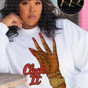 May include: White sweatshirt featuring a graphic of a hand with long red nails, gold jewelry, and a gold watch. The words "Clock It" are in red script. The sweatshirt is from KK's Kreations.