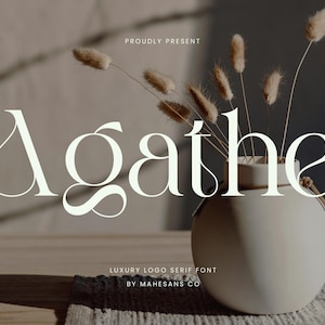 Puede incluir: Una composición minimalista con la palabra "Agathe" en una fuente serif, acompañada de un jarrón con flores secas. También se ve el texto "PROUDLY PRESENT" y "LUXURY LOGO SERIF FONT BY MAHESANS CO".
