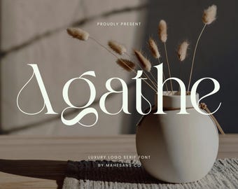 May include: A minimalist composition featuring the word "Agathe" in a serif font, accompanied by a vase with dried flowers. The text "PROUDLY PRESENT" and "LUXURY LOGO SERIF FONT BY MAHESANS CO" are also visible.