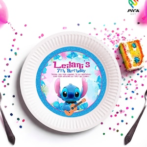 Puede incluir: Plato de papel blanco con un borde azul brillante y una imagen de dibujos animados de Stitch tocando la guitarra. El plato tiene el texto "Leilani's 7th Birthday". También se ven confeti y una porción de pastel.