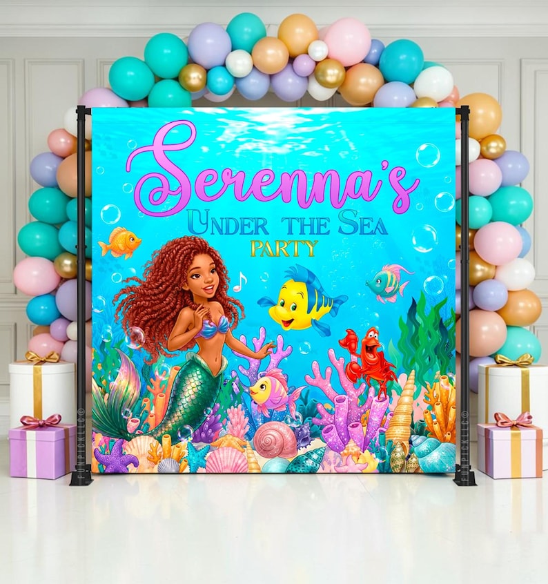 May include: A vibrant backdrop for a party, featuring a mermaid illustration with a teal tail, red hair, and a blue top. The backdrop is set against a blue underwater scene with fish, coral, and the text "Serenna's Under The Sea Party". Balloons in various colors frame the backdrop.