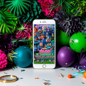 a smartphone displaying a colorful and vibrant birthday party invitation for a child named "Emma". The invitation includes details about the event, such as the date, time, and location, as well as the names of the guests and the theme of the party. The smartphone is surrounded by various party decorations, including balloons, flowers, and other colorful items, creating a festive atmosphere.