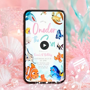 May include: A smartphone screen displaying a digital invitation for a first birthday party with the text Oneder the Sea, Emma's 1st Birthday, Saturday July 15 at 2pm, 2847 Meadow Lane, Austin, TX 78704, and RSVP by July 15 at 123-456-7890.
