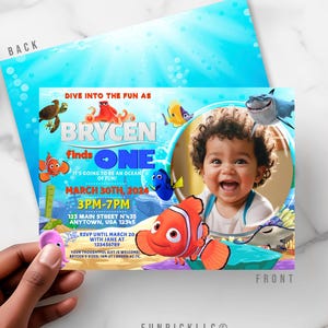 May include: A personalized invitation with a photo of a smiling child, featuring animated sea creatures. The invitation reads "Brycen finds ONE" with event details: March 30th, 2024, 3PM-7PM, and an address. The design includes a blue ocean background.