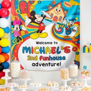 Pu&ograve; includere: Un colorato sfondo per feste con Topolino, Minnie e Paperino. Lo striscione recita "Welcome to MICHAEL'S 2nd funhouse adventure!" con una casa dei cartoni animati e un design arcobaleno. La scena comprende palloncini e un tavolo da dessert con varie prelibatezze.