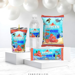 Puede incluir: Un conjunto de recuerdos de fiesta con el tema "Buscando a Nemo". Incluye una caja de jugo, una botella de agua, una bolsa de bocadillos y una barra de dulces, todos con el texto "Brycen Finds One" y gráficos de Nemo. Los artículos se muestran sobre una superficie blanca.