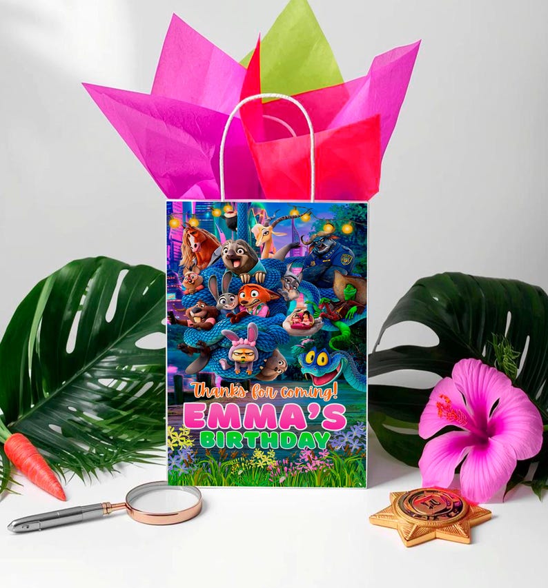 A colorful birthday bag with a cartoon character design, surrounded by tropical leaves, a magnifying glass, and a pink hibiscus flower.