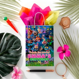 A birthday bag with a cartoon character design, surrounded by various party supplies and decorations, including a carrot, a magnifying glass, and a hibiscus flower.