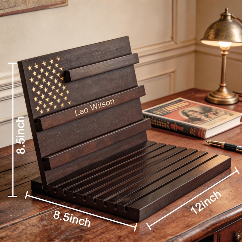May include: A dark brown wooden book stand with an American flag design and the name "Leo Wilson". The stand is 8.5 inches high and 12 inches wide. The stand has a series of horizontal slats to hold books.