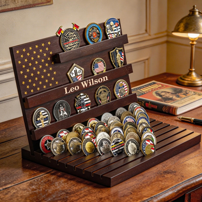May include: A dark wood coin display case with multiple shelves, holding a collection of coins. The case has a flag design with stars and stripes. The name "Leo Wilson" is displayed on the case.