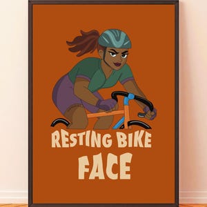 Peut inclure: Impression d'art encadrée représentant une cycliste avec une expression déterminée, portant un casque et faisant du vélo. L'œuvre d'art présente les mots "RESTING BIKE FACE" en lettres blanches en gras sur un fond orange.