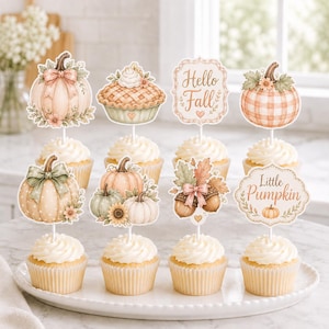 May include: A set of eight decorative cupcake toppers featuring watercolor illustrations of pumpkins, a pie, acorns, and autumn leaves. The designs include text that reads Hello Fall and Little Pumpkin, all mounted on white sticks for cupcakes.