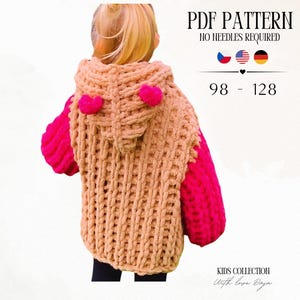 May include: A beige hooded jumper with bright pink sleeves and two small pink pom-poms on the hood. Text reads PDF PATTERN NO NEEDLES REQUIRED 98 - 128 KIDS COLLECTION With love Daja. The garment features a chunky, thick-yarn knit texture.