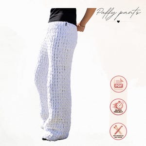Pode incluir: Calças de malha branca de fio grosso com uma textura volumosa. A imagem inclui o texto Puffy pants, PDF, QUICK PROJECT e NO NEEDLES NO HOOK, juntamente com ícones que representam um documento, um relógio e agulhas de tricô cruzadas.