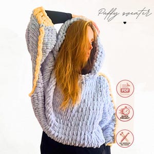 Puede incluir: Un suéter de punto grueso azul claro con capucha y ribetes amarillos a lo largo de las mangas. El texto Puffy sweater es visible, junto con iconos de PDF, proyecto rápido y sin agujas ni ganchillo, indicando un patrón para una prenda.