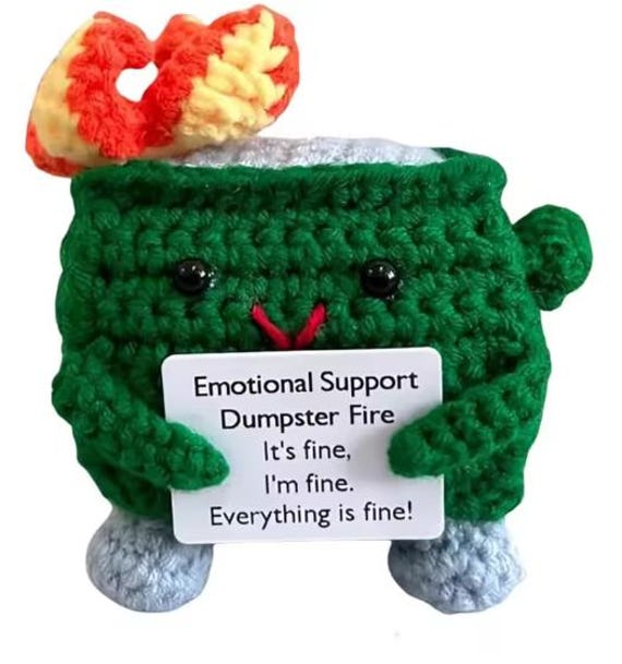 A hand-crocheted tiny dumpster on fire — the internet's favorite metaphor made tactile and huggable for your desk.