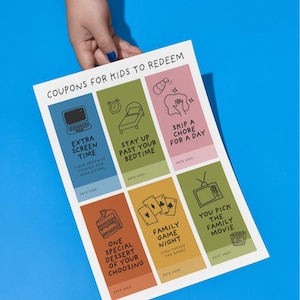 May include: A white sheet of paper with colorful coupons for kids to redeem. Each coupon has a different activity, such as extra screen time, skipping a chore, or choosing a family movie. The paper is held against a blue background.