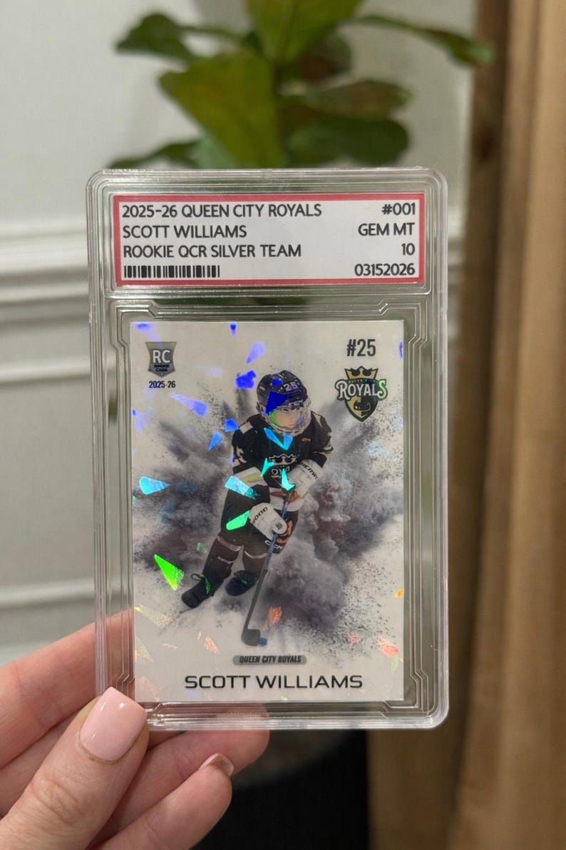 May include: A hockey trading card encased in a protective holder. The card features a player in a black and white uniform with the text "SCOTT WILLIAMS" and "QUEEN CITY ROYALS". The card is graded as GEM MT 10.