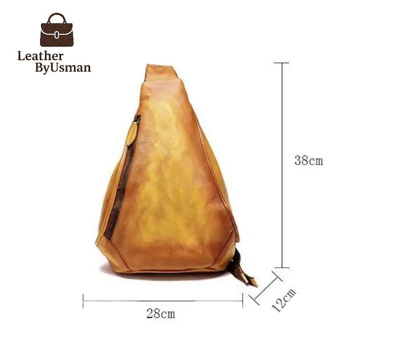 May include: A tan leather sling bag with a zipper closure and a small pocket. The bag is 15 inches tall, 11 inches wide, and 4.7 inches deep. The bag has the text "Leather By Usman" on the top left.