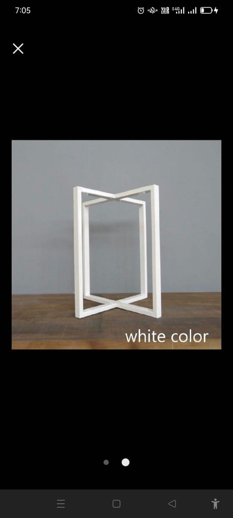 May include: White, geometric side table with an open, rectangular design. The table has an X-shaped base and a rectangular top. The text "white color" is at the bottom. The table is on a wooden surface.
