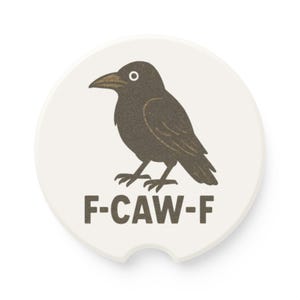 Op de afbeelding: Een witte auto-onderzetter met een zwarte kraaienillustratie en de tekst "F-CAW-F". De kraai is afgebeeld in een vintage stijl met een getextureerde uitstraling. De onderzetter heeft een gebogen inkeping voor gemakkelijk verwijderen.