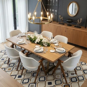 Puede incluir: Una taza de cerámica blanca con un asa negra y el texto "But First, Coffee" en negrita negra. La taza está sobre una superficie de madera. La taza mide 10 cm de alto.