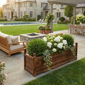 Wood planter box near garden fence with plants growing