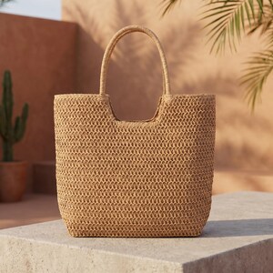 May include: A woven straw tote bag with a rectangular shape and a handle. The bag is a light brown color and has a textured appearance. The background features a neutral-toned wall and potted plants, suggesting a natural theme.