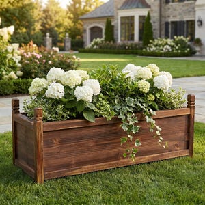 Wood raised planter box placed on green lawn with plants inside